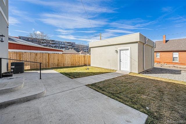 exterior space with an outbuilding, cooling unit, a patio area, and fence