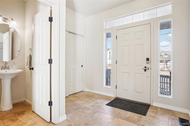 4844 Mt Evans St, Brighton, CO 80601 - entrance foyer with healthy amount of natural light, baseboards, and light stone finish flooring