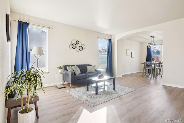 4844 Mt Evans St, Brighton, CO 80601 - living area with arched walkways, light wood finished floors, healthy amount of natural light, and baseboards