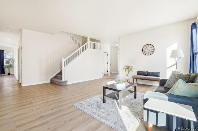4844 Mt Evans St, Brighton, CO 80601 - living room featuring stairs, wood finished floors, and baseboards