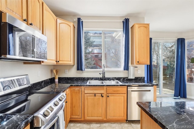 4844 Mt Evans St, Brighton, CO 80601 - kitchen with appliances with stainless steel finishes, a sink, dark stone counters, and light brown cabinetry