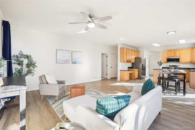 4844 Mt Evans St, Brighton, CO 80601 - living room with light wood-type flooring, baseboards, and a ceiling fan