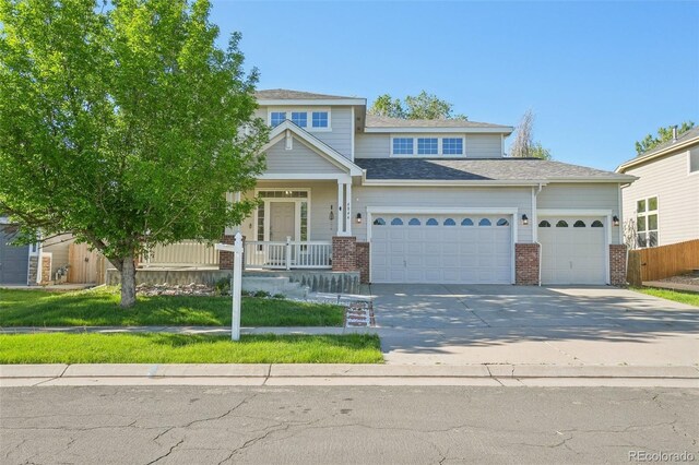 4844 Mt Evans St, Brighton, CO 80601 - view of front facade with an attached garage, brick siding, concrete driveway, and covered porch