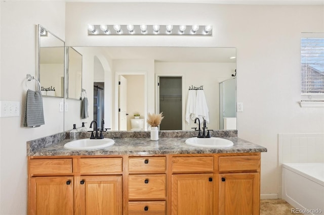 4844 Mt Evans St, Brighton, CO 80601 - bathroom featuring double vanity, a garden tub, and a shower with door