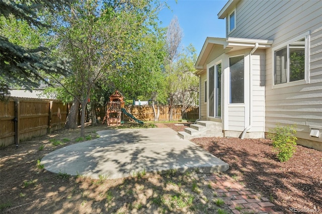 4844 Mt Evans St, Brighton, CO 80601 - fenced backyard featuring a playground, a patio area, and entry steps
