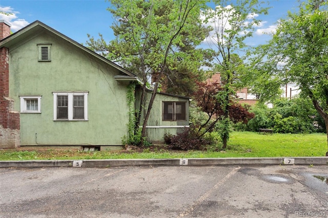 1900 S University Blvd, Denver, CO 80210 - view of side of home with stucco siding, uncovered parking, and a yard