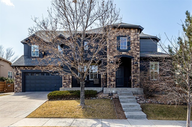 view of front of house with a garage, stone siding, a front lawn, and concrete driveway