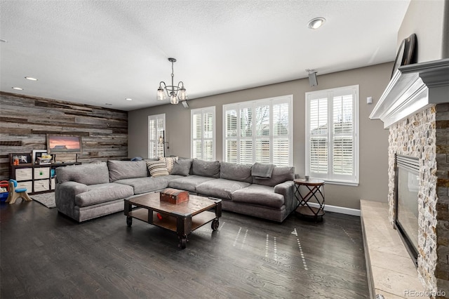 living room featuring an accent wall, a fireplace, wood walls, and wood finished floors