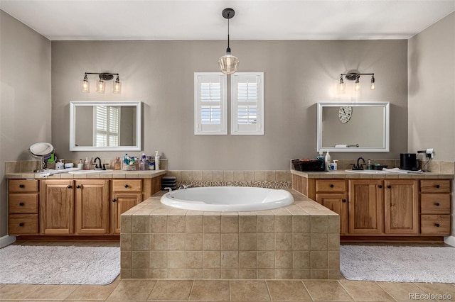 bathroom with two vanities, a sink, and a bath