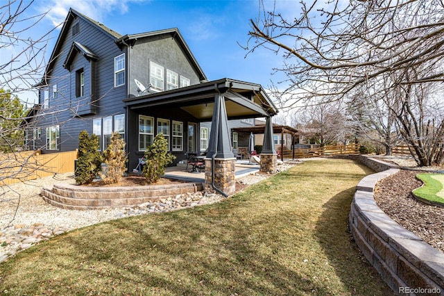 back of house with a patio and a lawn