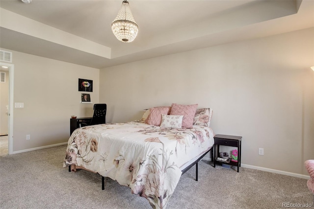 bedroom with a notable chandelier, a tray ceiling, carpet, and baseboards