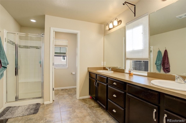 bathroom with a sink, visible vents, and a shower stall