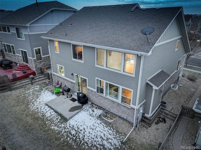 back of property featuring entry steps, a patio, and roof with shingles