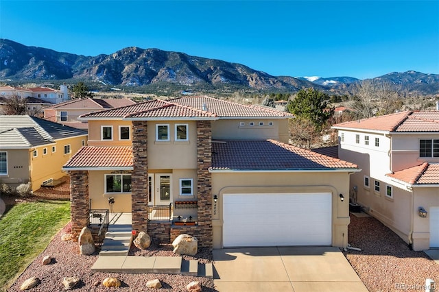 mediterranean / spanish-style house with a mountain view and a garage