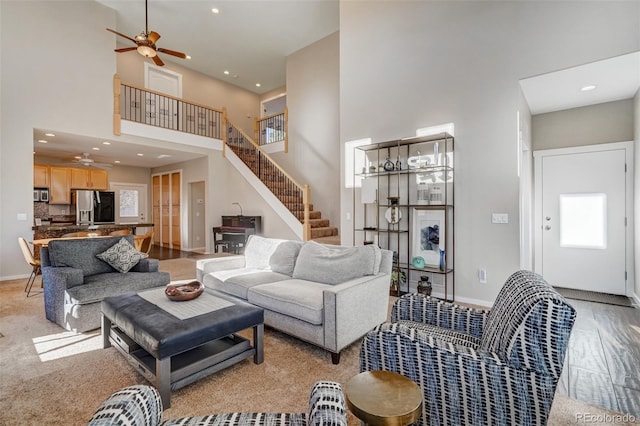 living room with ceiling fan and a high ceiling