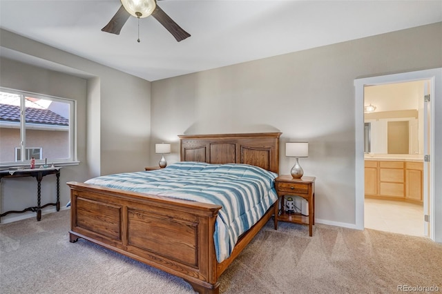 bedroom with ensuite bathroom, ceiling fan, and light colored carpet