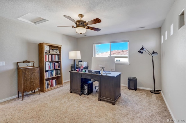 carpeted office space with a textured ceiling and ceiling fan