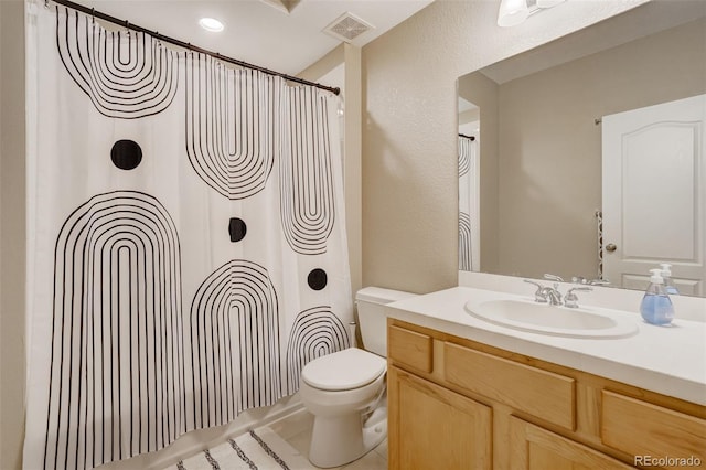 bathroom featuring tile patterned flooring, vanity, and toilet