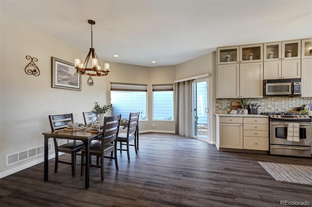 dining room with dark wood-type flooring and a chandelier