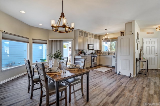 dining area featuring dark hardwood / wood-style floors, sink, an inviting chandelier, and plenty of natural light