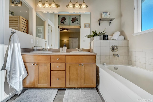 bathroom featuring ceiling fan, vanity, and a tub