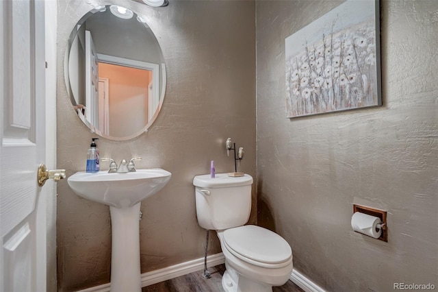 bathroom featuring toilet, sink, and hardwood / wood-style floors