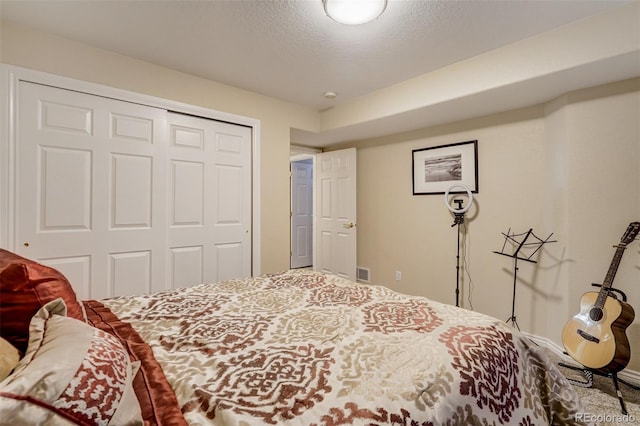 bedroom with a textured ceiling and a closet