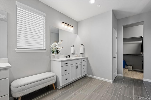 624 Simmental Loop, Castle Rock, CO 80104 - full bath featuring vanity, a spacious closet, plenty of natural light, and wood finish floors