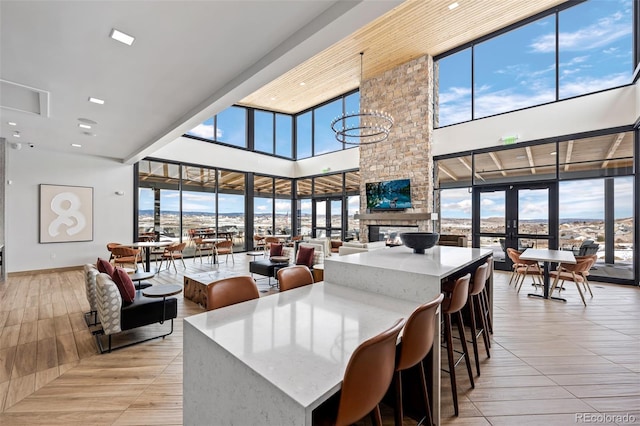 624 Simmental Loop, Castle Rock, CO 80104 - dining space featuring a high ceiling, healthy amount of natural light, a stone fireplace, french doors, and expansive windows