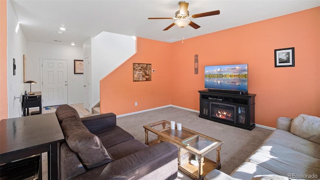 carpeted living room with stairway, a ceiling fan, baseboards, recessed lighting, and a glass covered fireplace