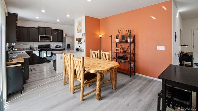 dining area with recessed lighting, light wood-style flooring, and baseboards