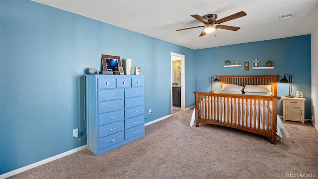 carpeted bedroom with ensuite bath, visible vents, a ceiling fan, and baseboards