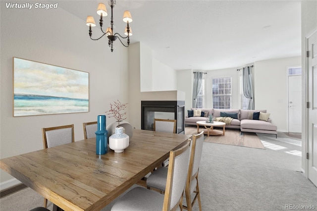 dining area featuring a chandelier, carpet flooring, visible vents, baseboards, and a multi sided fireplace