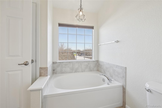 full bathroom with a garden tub and toilet