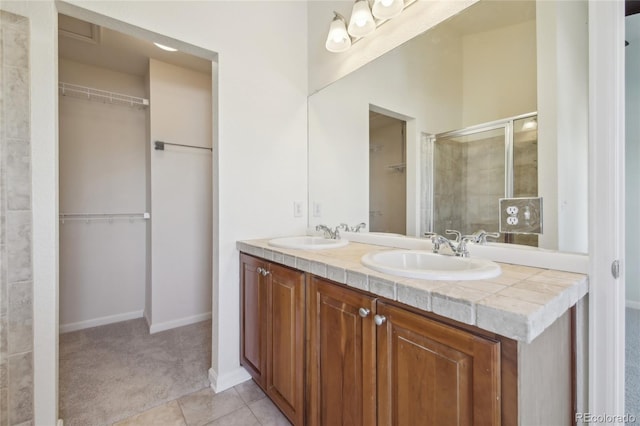 full bath featuring a shower stall, a spacious closet, and a sink