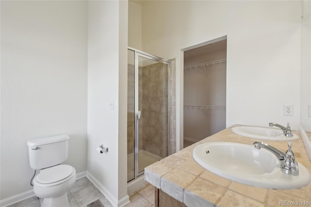 bathroom featuring a stall shower, a sink, and tile patterned floors