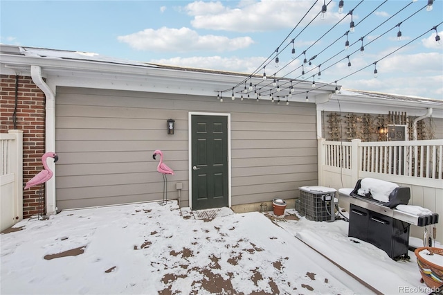 snow covered garage featuring fence