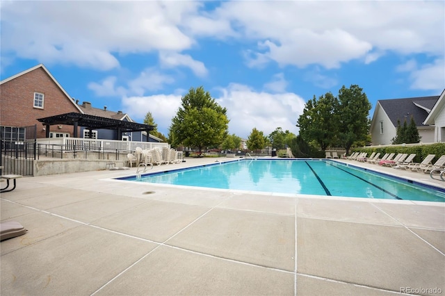 community pool with a patio area, fence, and a pergola