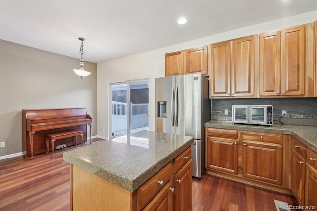 kitchen with a toaster, decorative backsplash, dark wood-type flooring, and stainless steel fridge with ice dispenser