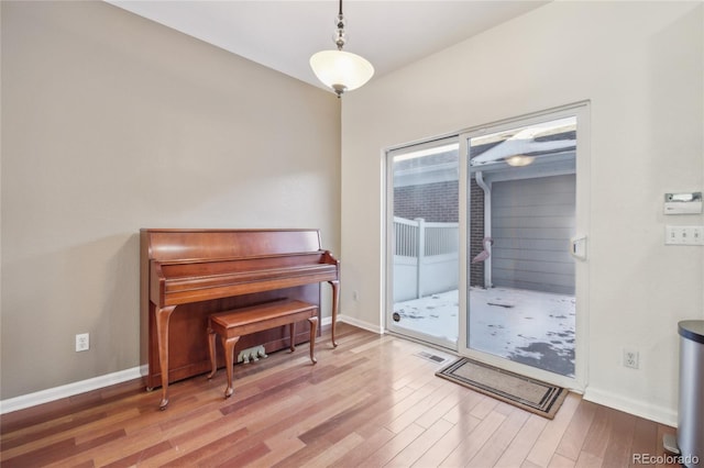 sitting room with visible vents, baseboards, and wood finished floors