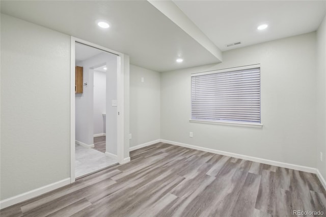 spare room featuring recessed lighting, visible vents, baseboards, and wood finished floors