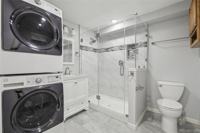 clothes washing area featuring baseboards, laundry area, a sink, and stacked washer / drying machine