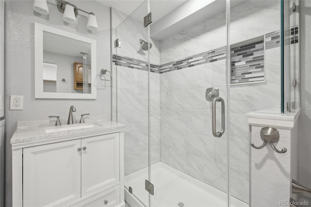 bathroom with a stall shower and vanity