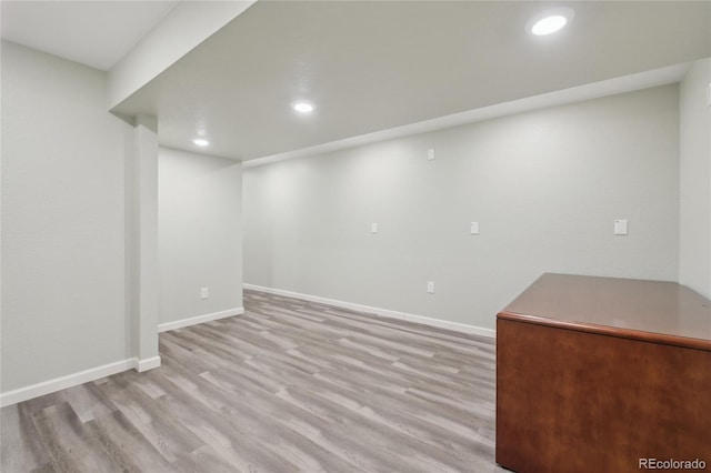 finished basement featuring recessed lighting, light wood-style flooring, and baseboards