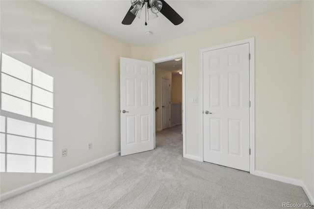 unfurnished bedroom with light carpet, ceiling fan, and baseboards