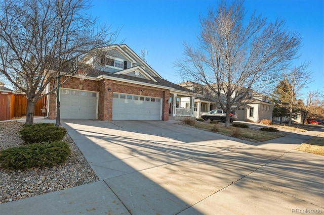 view of front facade featuring a garage, fence, concrete driveway, and brick siding