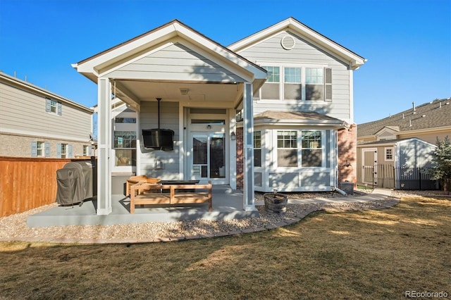 back of property with a patio, a yard, and fence