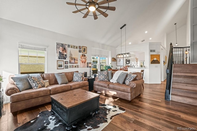 living area with dark wood-style floors, high vaulted ceiling, stairway, and ceiling fan