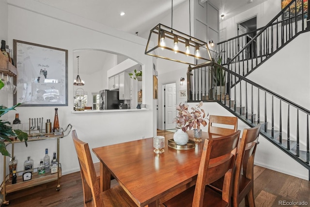 dining space with stairs, a high ceiling, wood finished floors, and recessed lighting