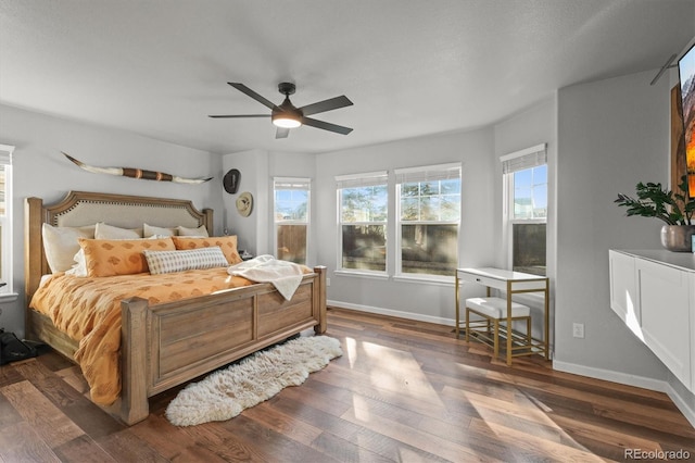 bedroom with ceiling fan, baseboards, and wood finished floors